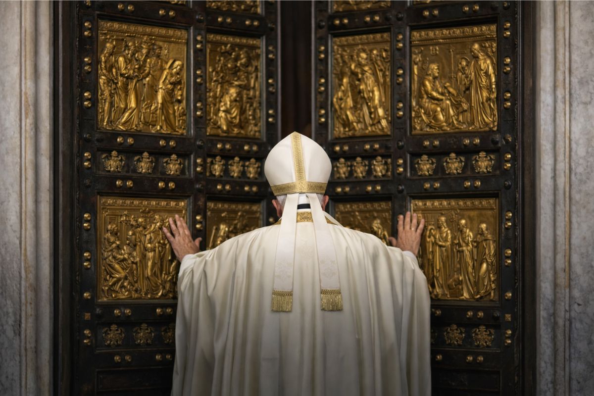 Le Vatican lance ses propres indices boursiers : foi et marchés face à face Le pape de dos devant la Porte Sainte du Vatican, ornée de panneaux dorés sculptés.